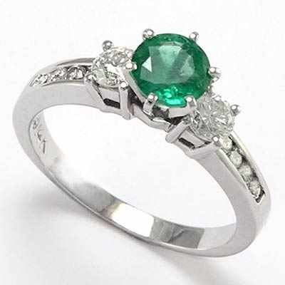 Round shaped diamond and emerald ring